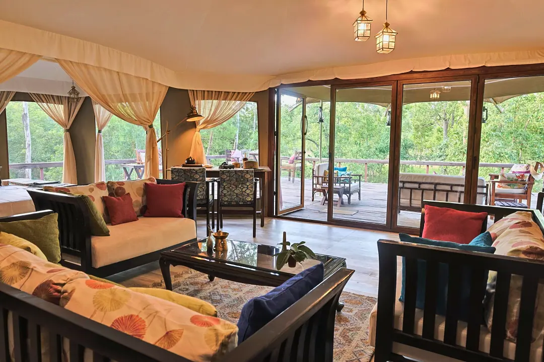 The sitting area of the Chief's Tent, its glass doors open to the forest
