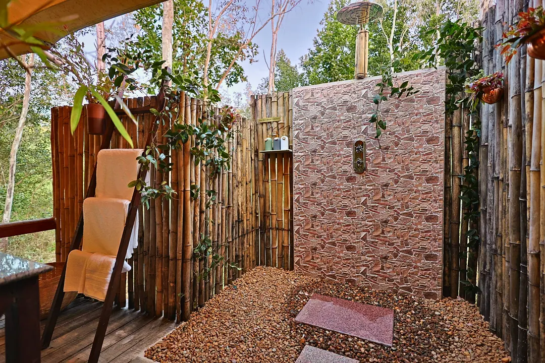 The King's Tent's outdoor shower screened with bamboo and stone
