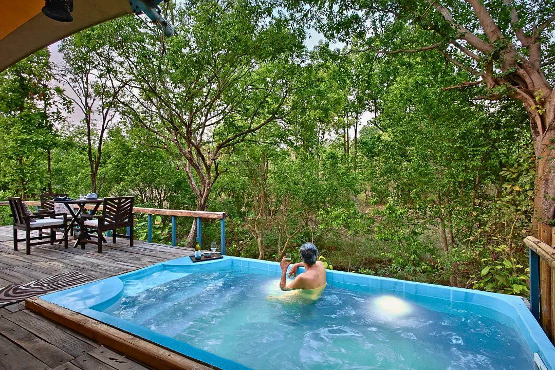 A guest in the plunge pool with the forest all around